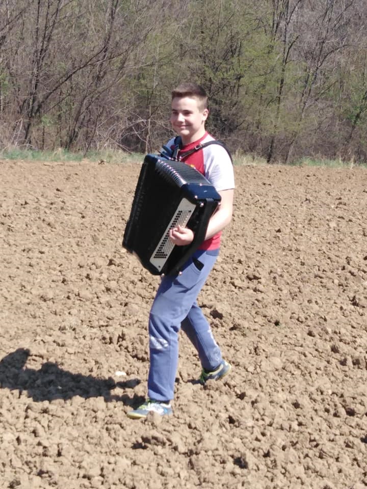 Млади Зечевић хармонику свира на њиви, фото: М. Лазаревић